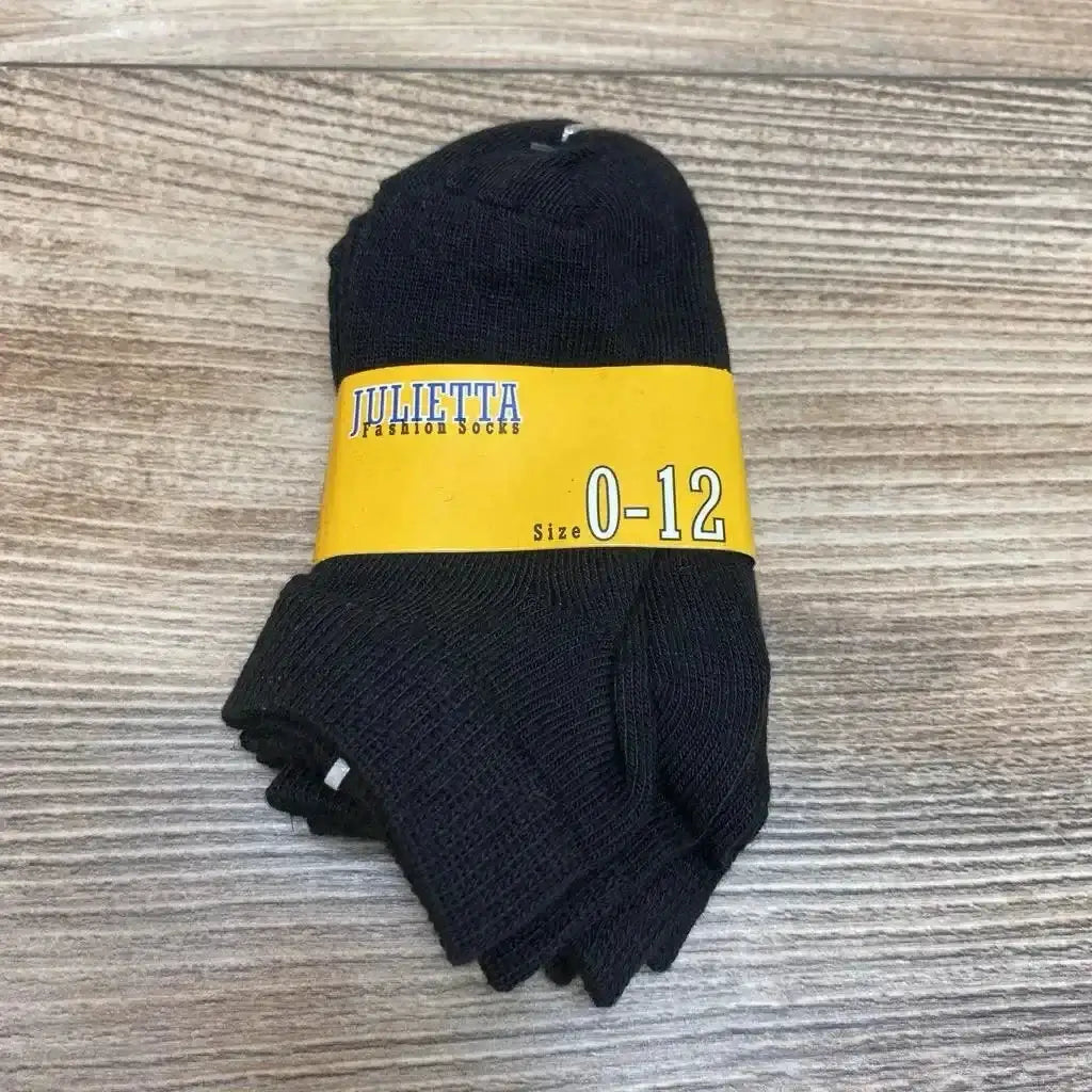 Top-down view of three black baby socks folded in a 3-pack with a yellow band reading 'Julietta Size 0-12' on a wood surface