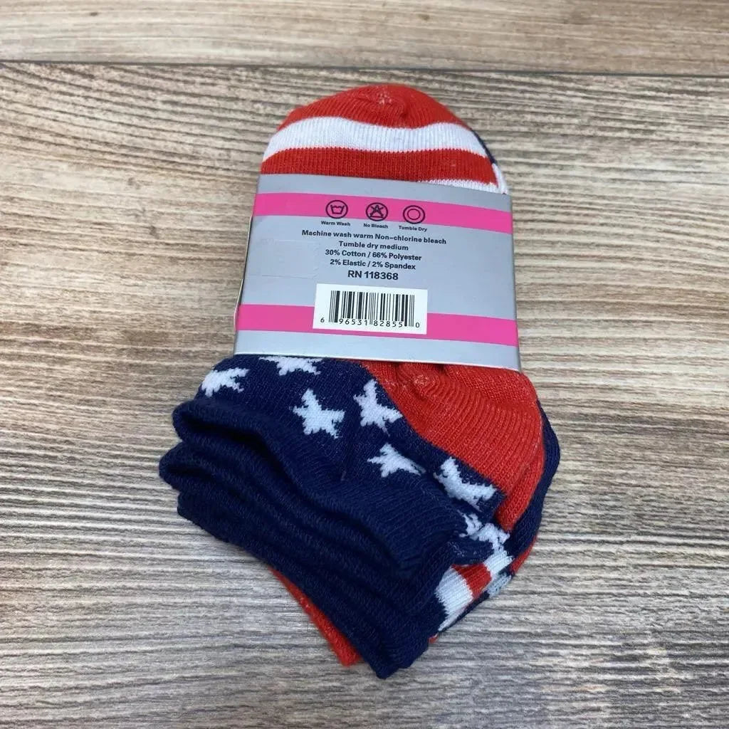 Top-down view of 3-pack toddler socks (size 2-3) in red, white, and navy with stars and stripes pattern, folded with paper label on wood surface
