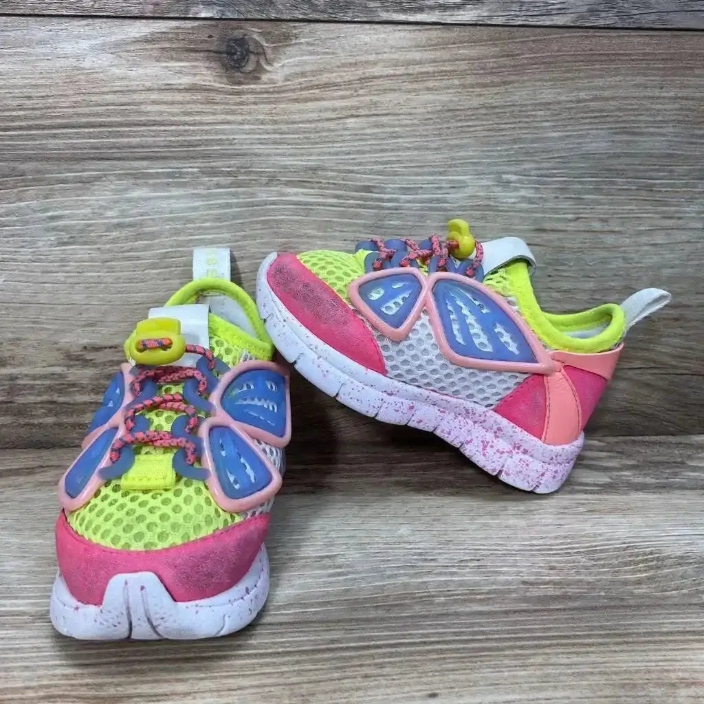 Front and side view of Sophia Webster Mini Chiara sneakers with yellow mesh, pink toe, blue butterfly accents on wood