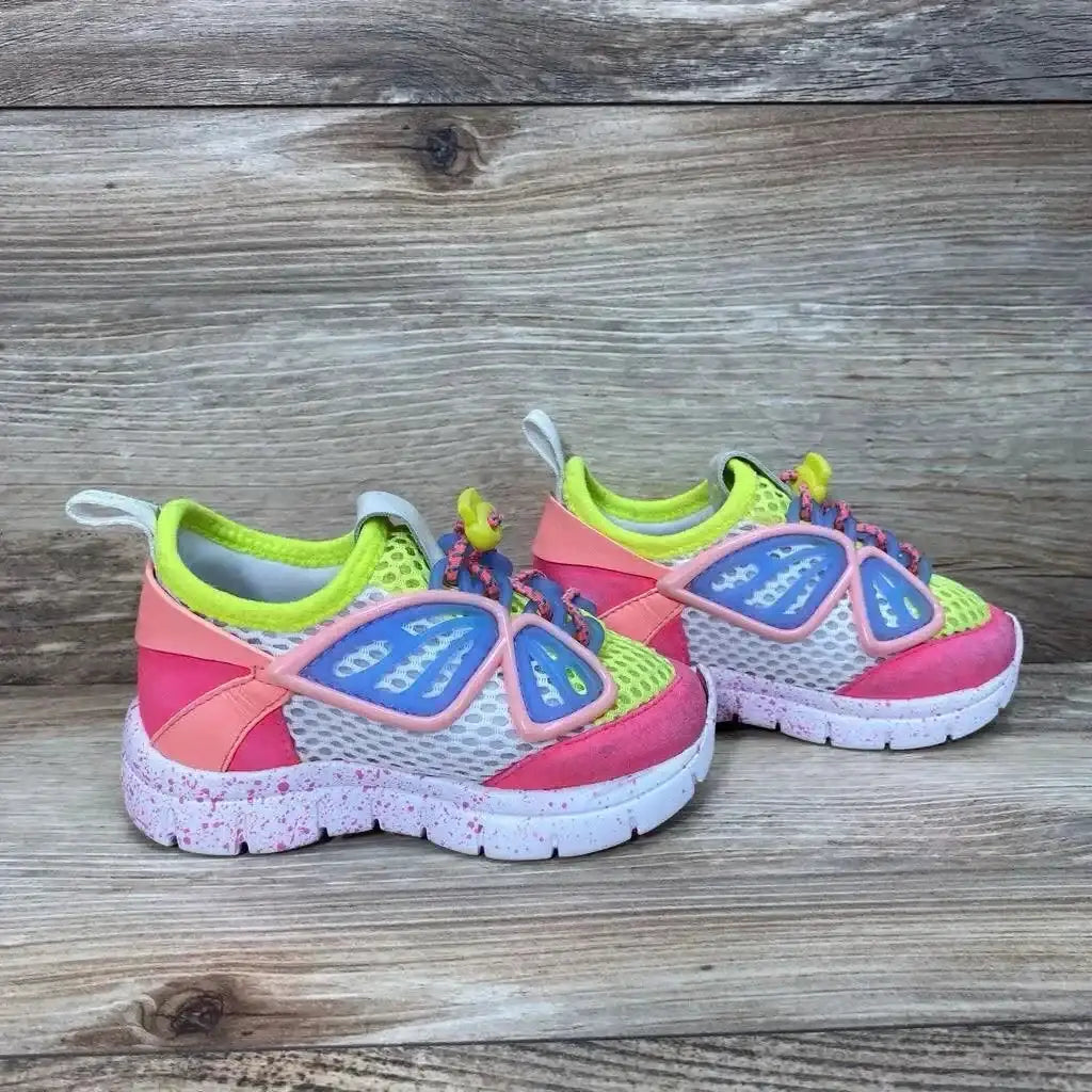 Side view of Sophia Webster Mini Chiara sneakers showcasing neon yellow pink and blue butterfly mesh with speckled sole on wood