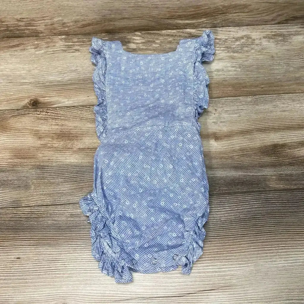 Flat lay of blue striped numi romper (3T) showing ruffle sleeves, small white floral print, and snap crotch on wood floor