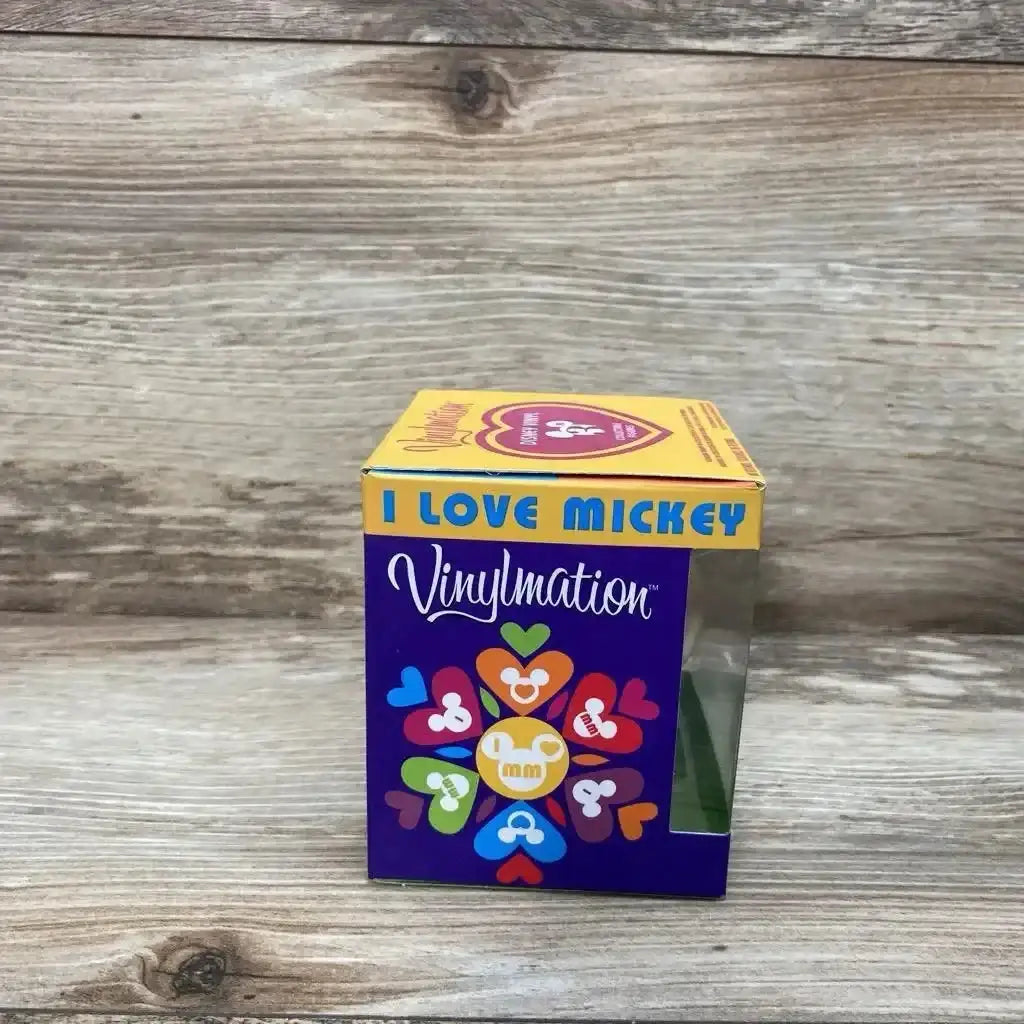 Front view of 3-inch Vinylmation 'I Love Mickey' boxed figure showcasing colorful heart-pattern packaging and clear display window on wood background
