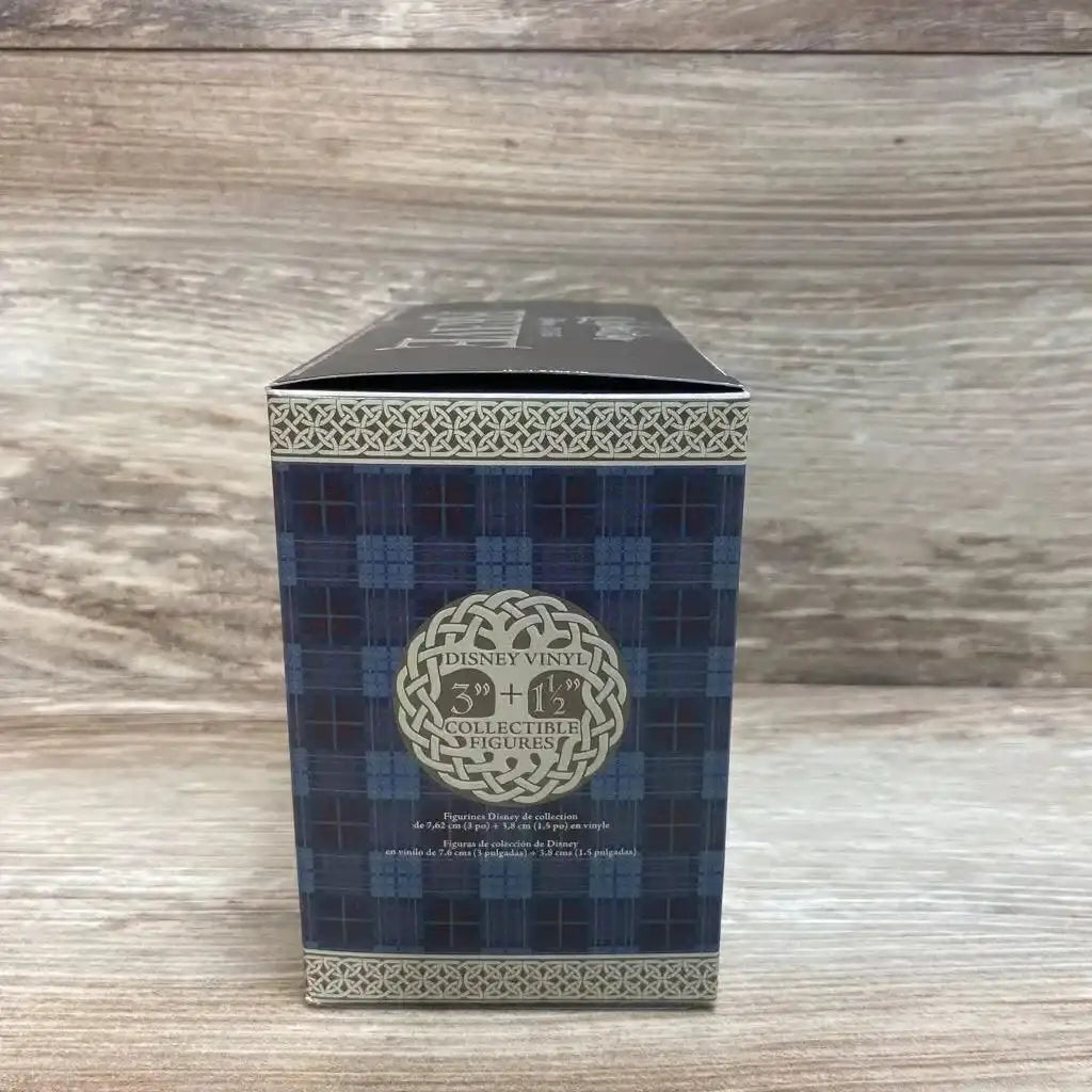 Front of Vinylmation Disney Brave 4pc set box showing tartan panel and Disney Vinyl logo on wood background