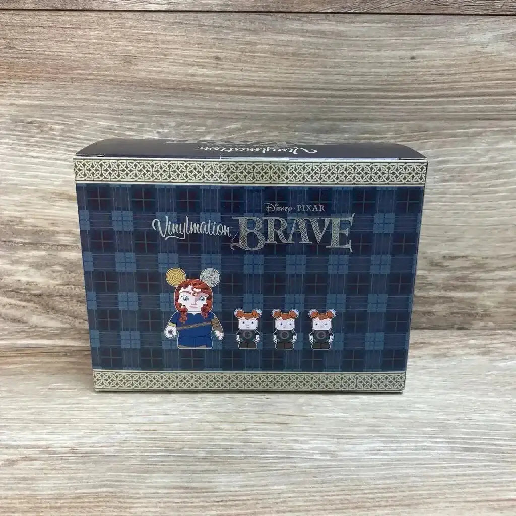 Front view of Vinylmation Brave 4-piece box with tartan design and Merida plus three bear figures on wood