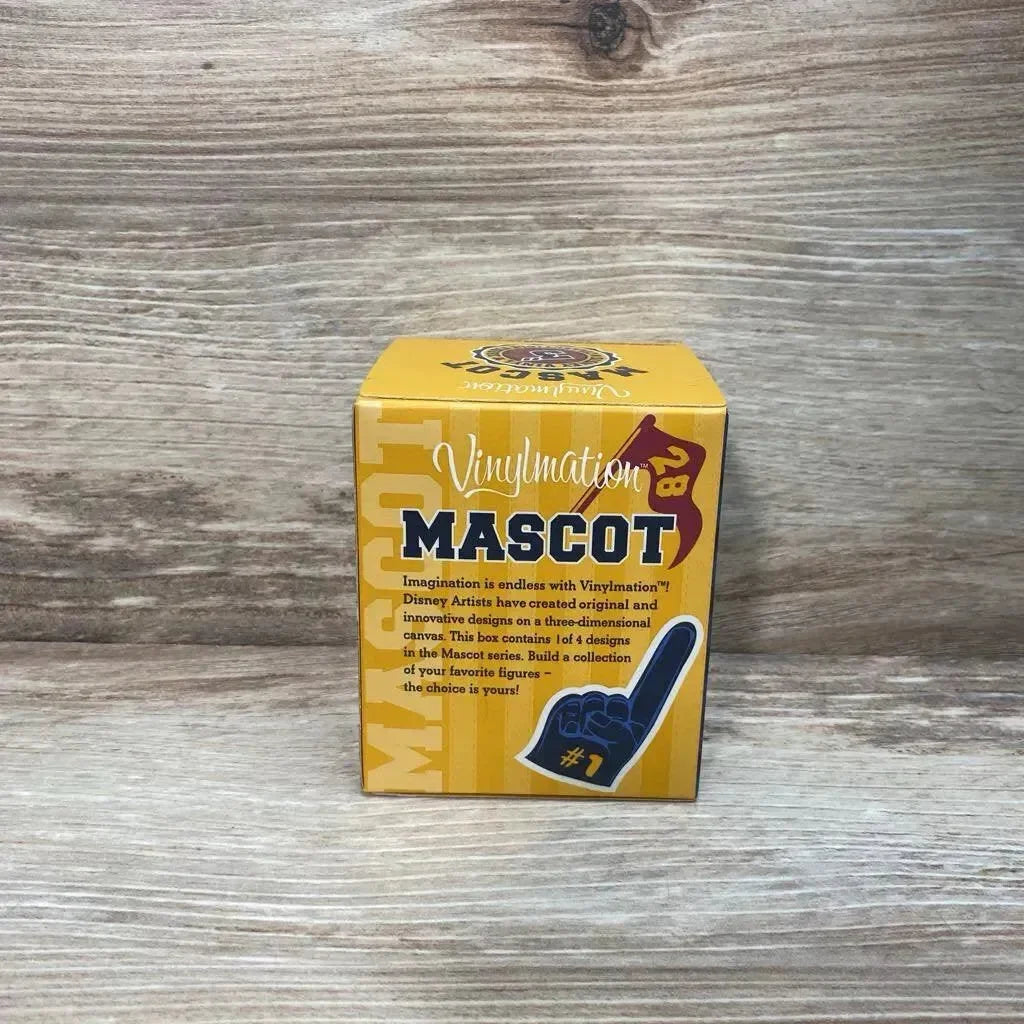 Front of Vinylmation Pluto mascot box showing yellow 'MASCOT' packaging and foam-finger graphic on wood background