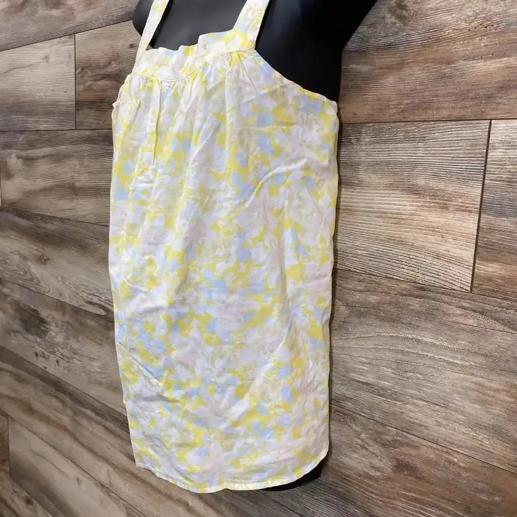 Front view of yellow floral tank top (size medium) showing gathered neckline and thin straps on mannequin against wood wall