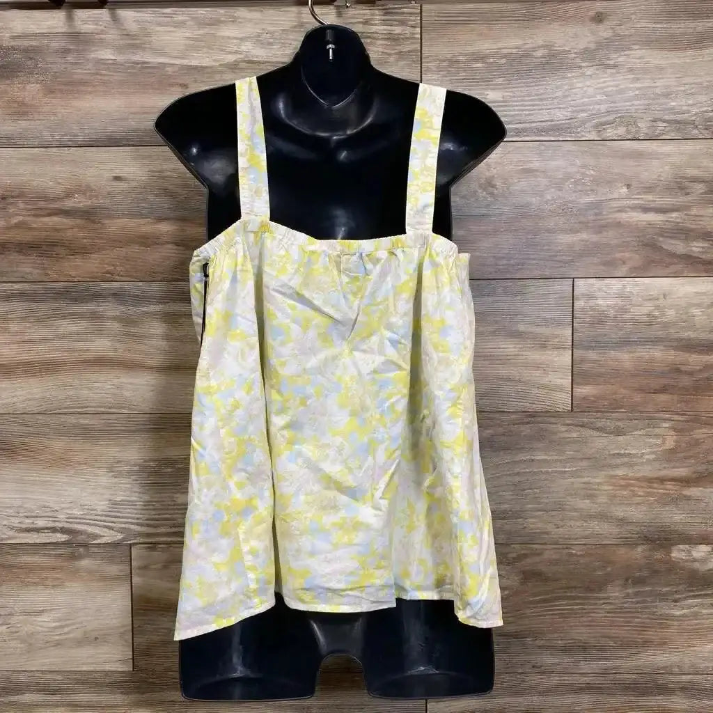 Front view of yellow floral tank top with square neckline and wide straps on a black mannequin against wood background