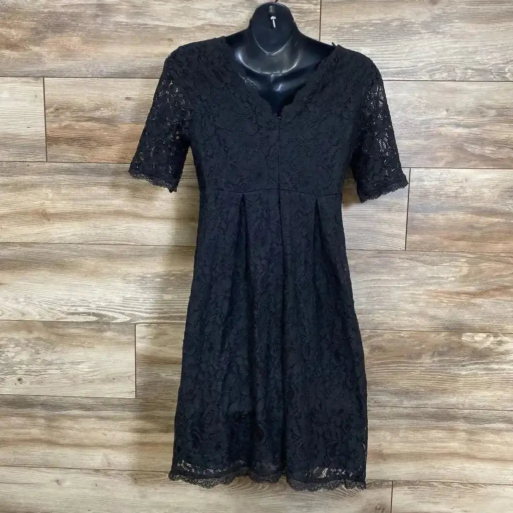 Front view of Motherhood Maternity black lace fit-and-flare dress, size M, V-neck and short lace sleeves against wood wall