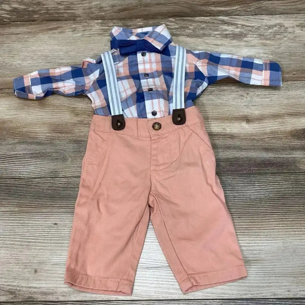 Front flat lay of baby plaid button-up shirt with navy bow tie, striped suspenders and peach pants on wood background