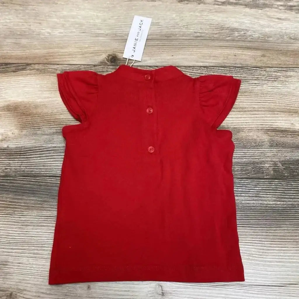 Back view of Janie & Jack red baby top showcasing ruffle sleeves and button closure with light wood background