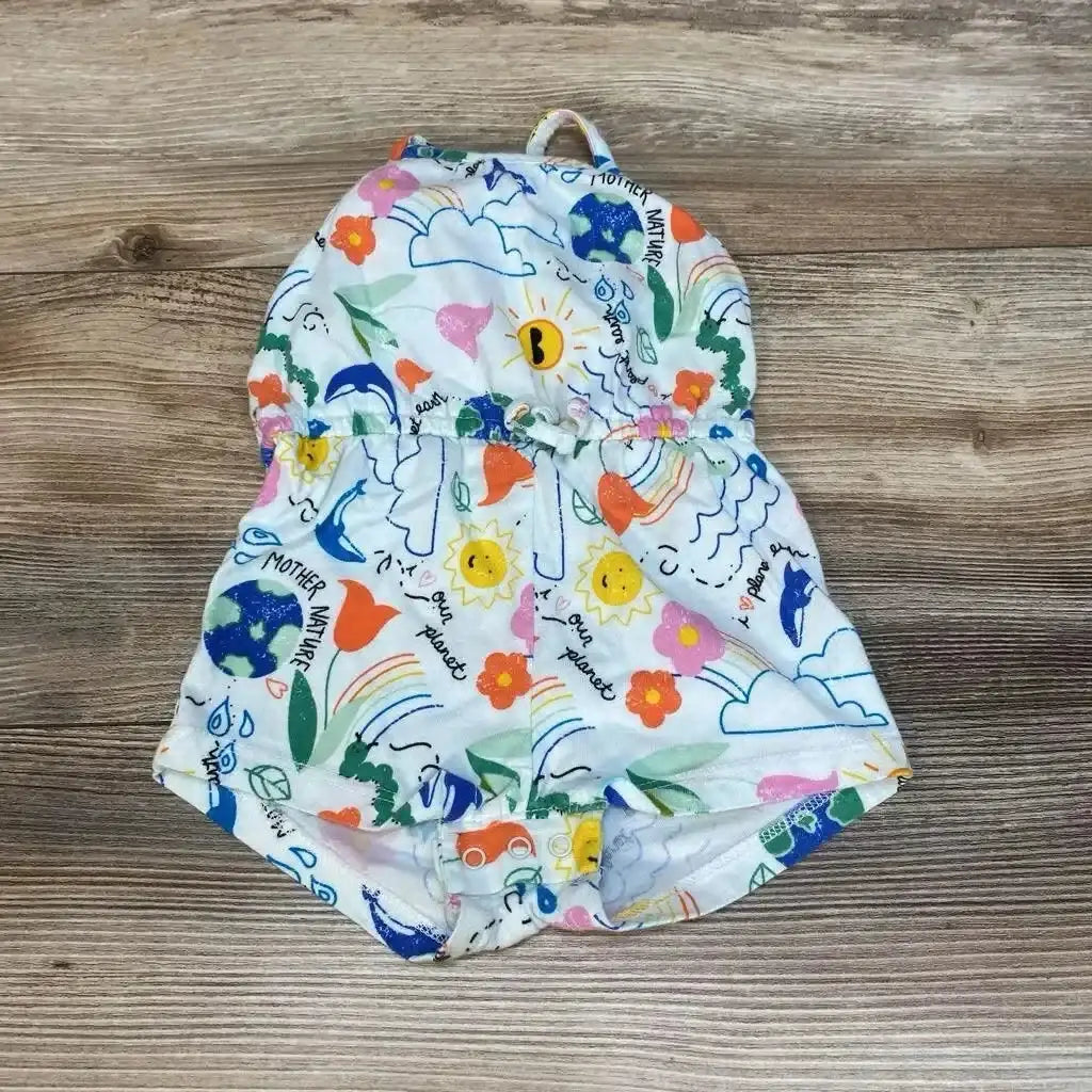 Flat-lay of Old Navy Mother Nature romper, 0-3M, showcasing a hood and snap crotch with white fabric printed with colorful suns, rainbows, and earth on wood background