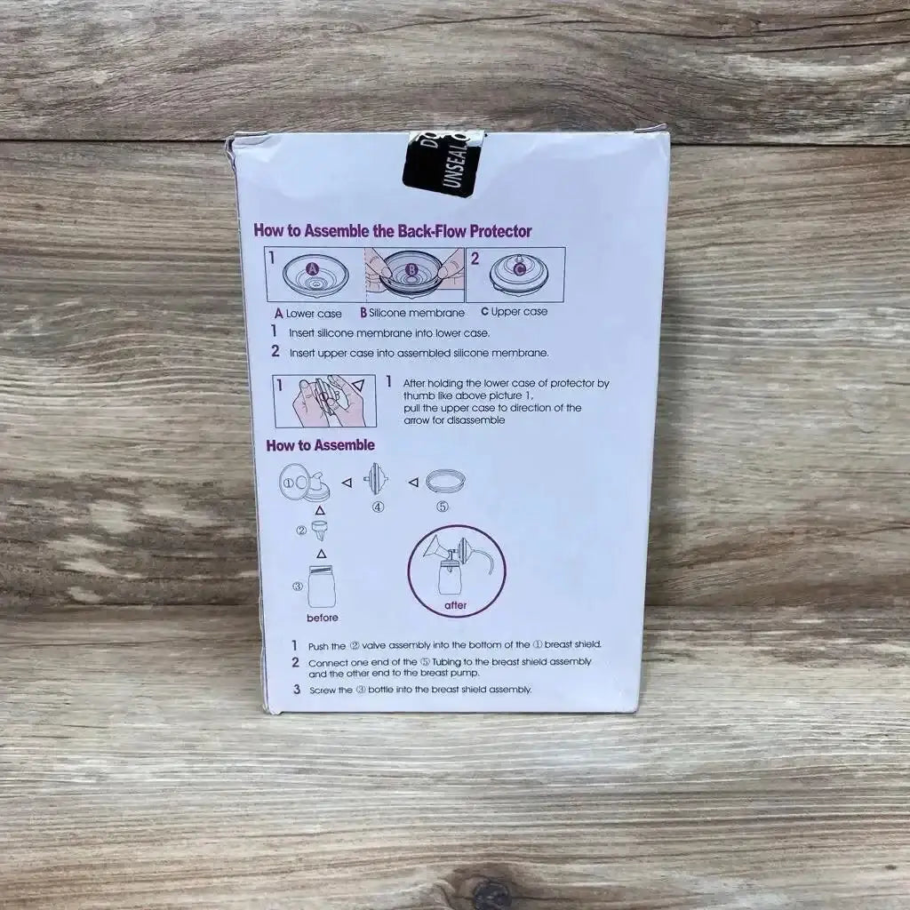 Rear view of Spectra 28mm breast shield accessory kit box showing assembly instructions on white box against wood background