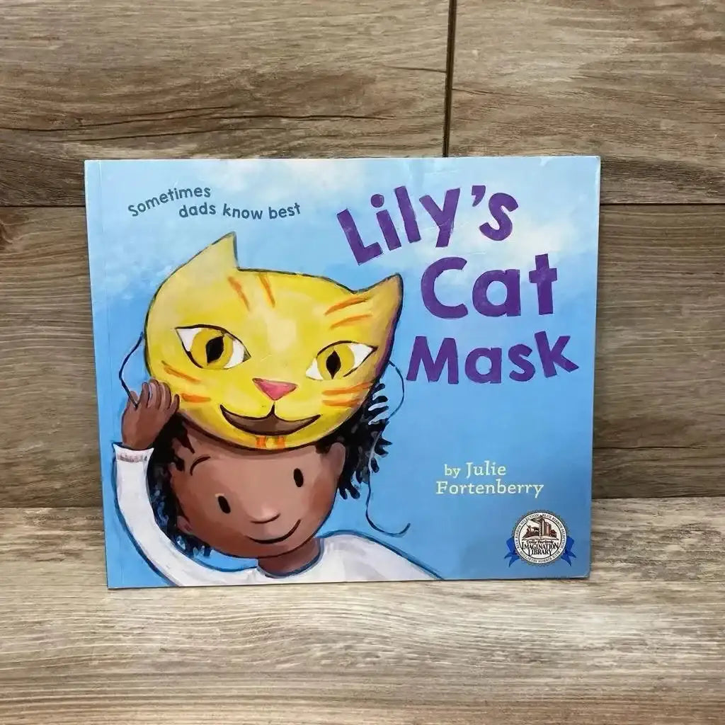 Front cover of Lily’s Cat Mask paperback showcasing child wearing a yellow cat mask and purple title text on wooden surface