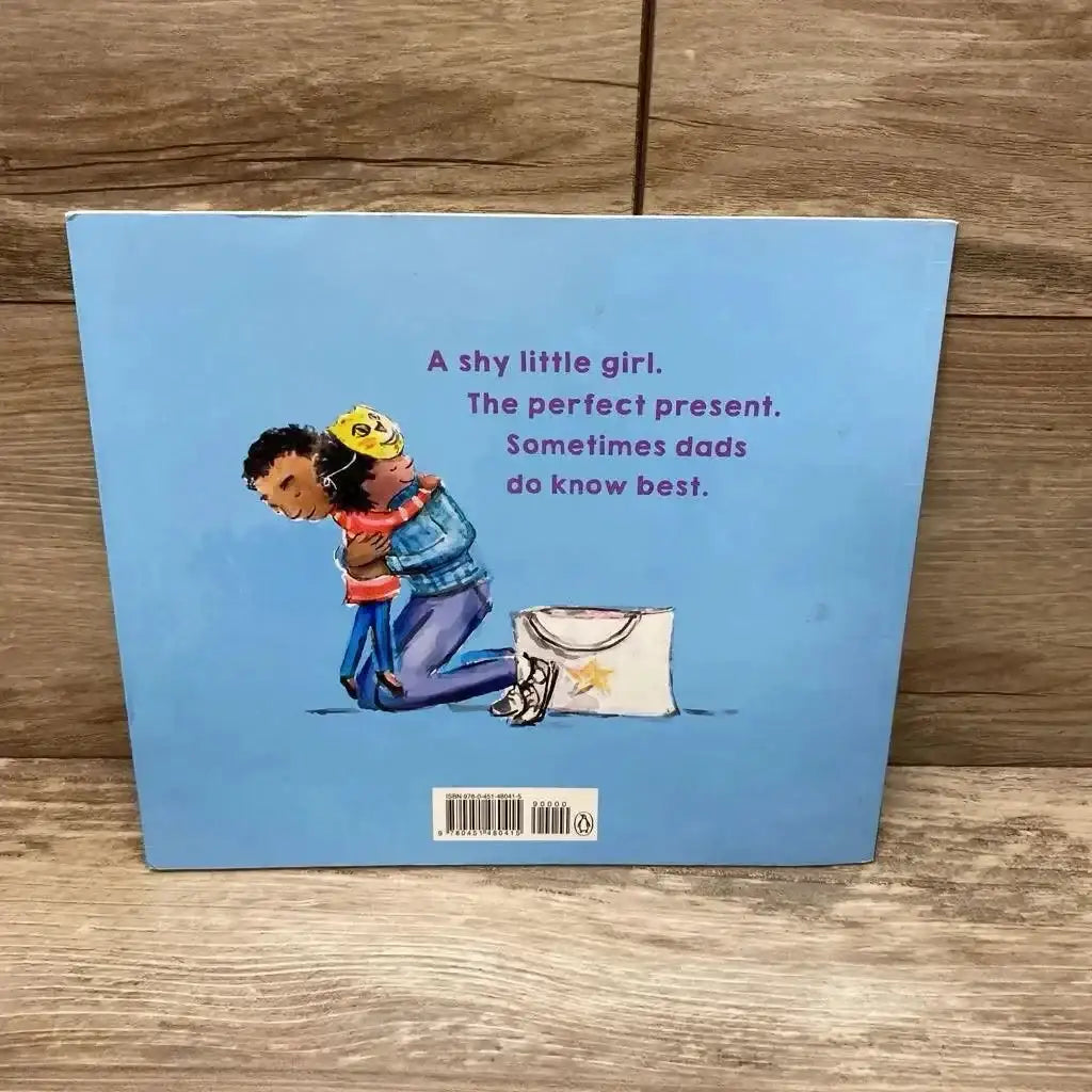 Back view of Lily’s Cat Mask paperback showing a father hugging a child and purple tagline text on wood background