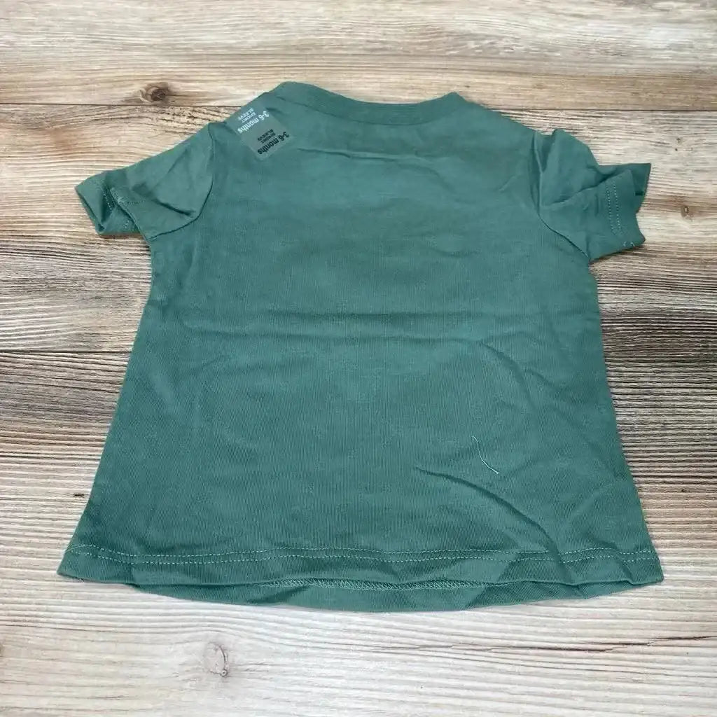 Back view of green First Impressions baby t-shirt size 3-6 months showing short sleeves and crew neck on wood background