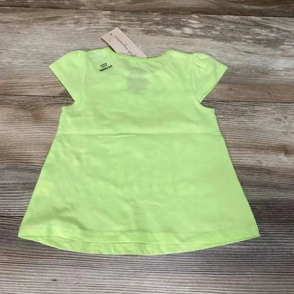 Front view of First Impressions green baby shirt (6–9m) showing yellow sun graphic on chest against white background