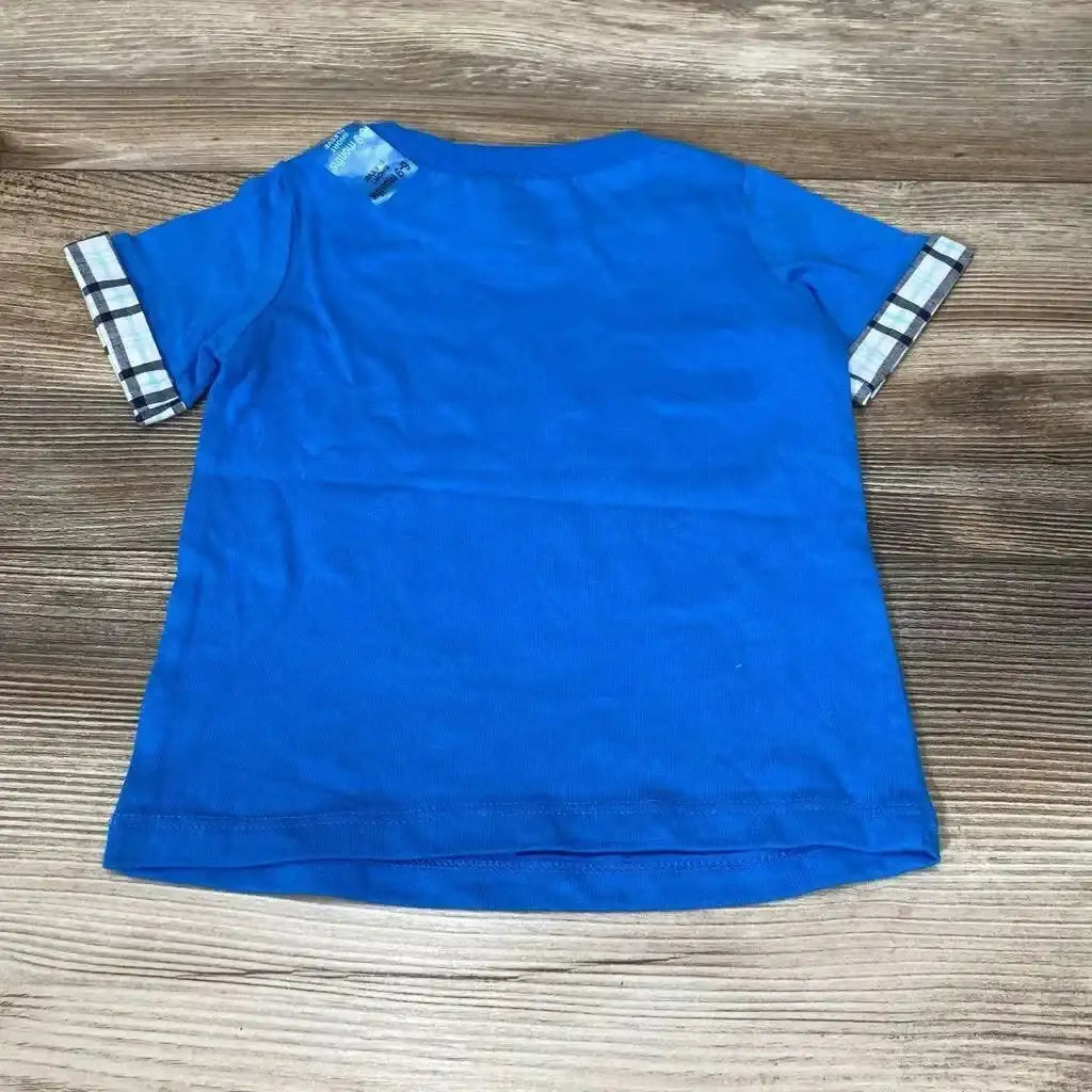 Back view of blue baby T-shirt, short sleeves with plaid-rolled cuffs, size 6-9 months on wood background