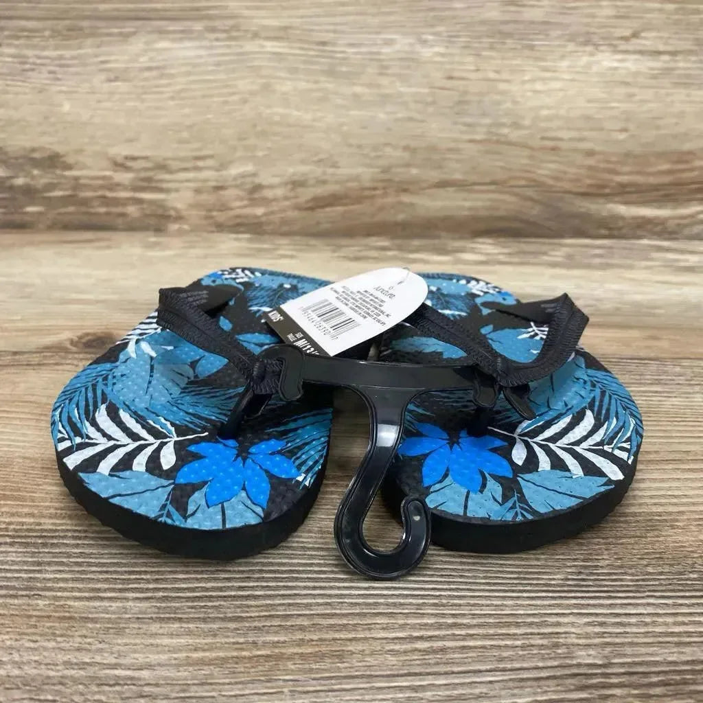 Front view of toddler blue jungle-print sandals size 13C showcasing black thong straps and tropical leaf and flower pattern on a wood surface