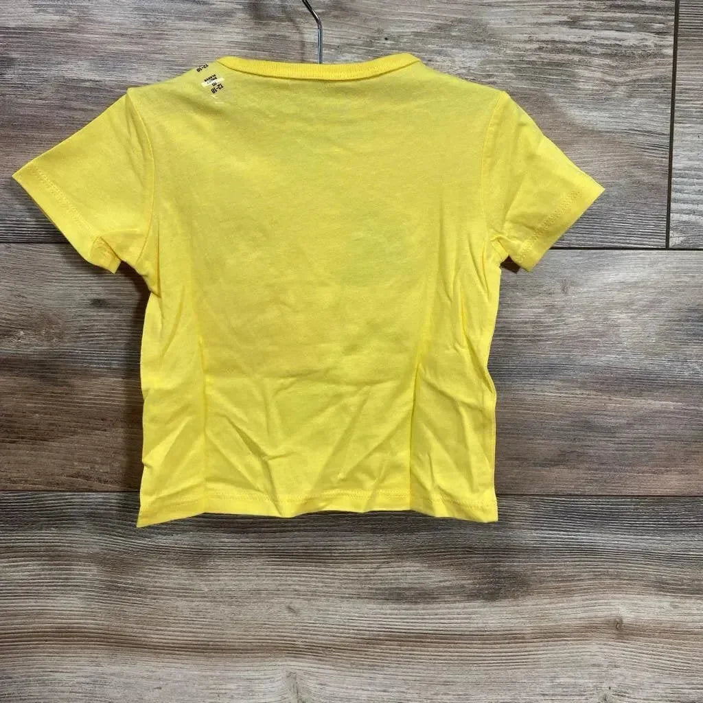 Back view of Children's Place yellow toddler t-shirt 12-18M showcasing plain back and short sleeves with wood floor background