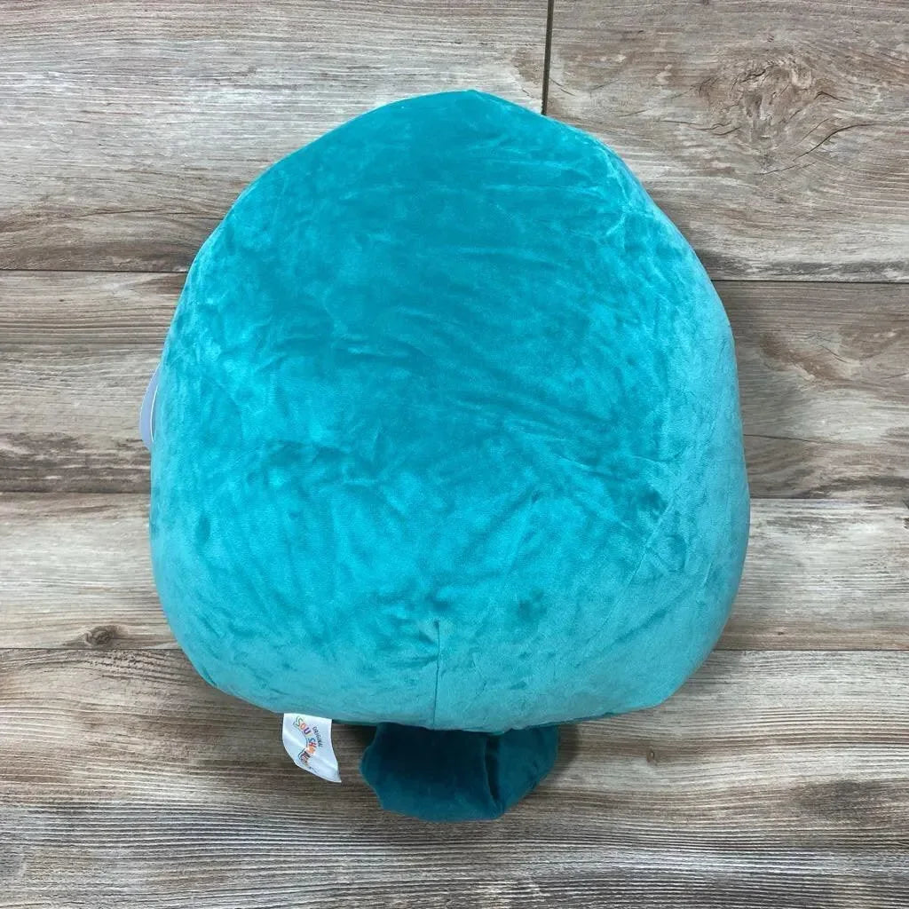 Top view of 14-inch Selassi green platypus Squishmallow showcasing plush green fur and small tail on wood background