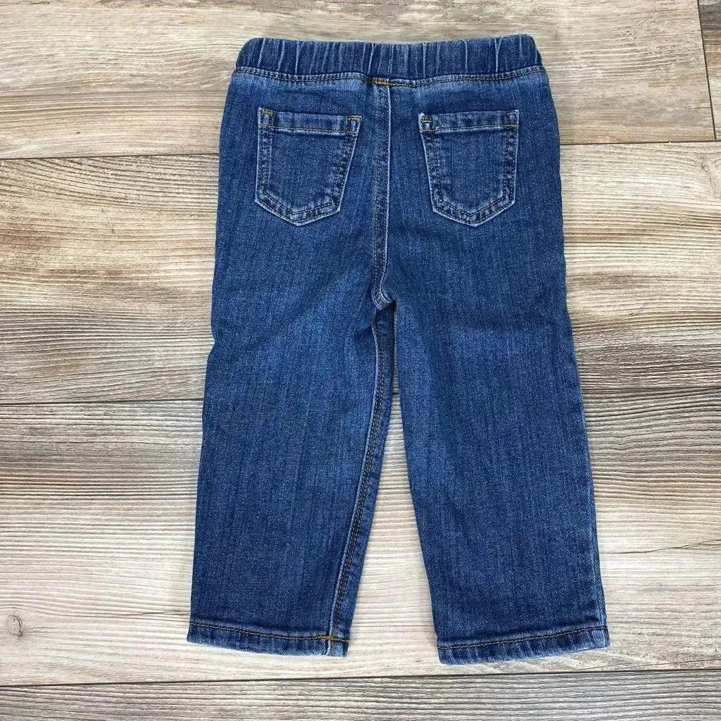 Back view of blue Jumping Beans straight-fit toddler jeans size 18m showing elastic waistband and back pockets on wood floor