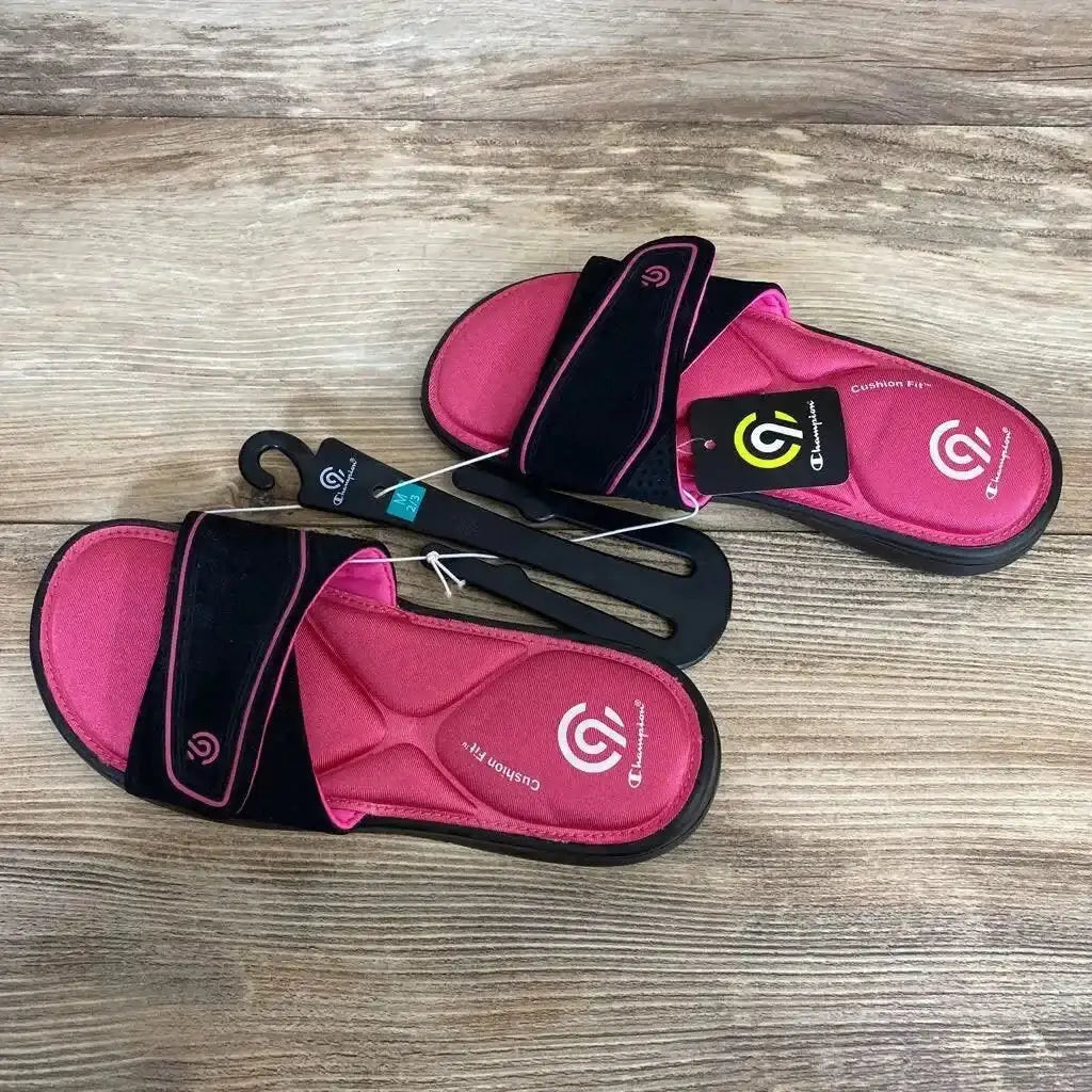 Top-down view of pink and black C9 Valma slides showing cushioned footbed and adjustable velcro strap on wood background
