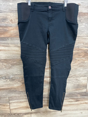 Black moto-style maternity pants with ribbed knee panels and ankle zippers, flat lay on wood