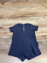 Flat lay of navy ribbed Henley shortie romper (3M) showing two wooden buttons and short sleeves on wood background