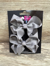 Front view of medium grey grosgrain hair bows 2 pack showing looped bows on black display card over wood background