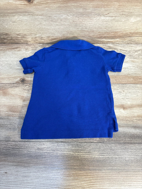 Back view of Ralph Lauren boys short-sleeve polo shirt, royal blue, size 12 months, showing collar and side vents on wood background