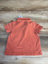 Coral baby onesie with short sleeves and ribbed texture, laid flat on wood surface