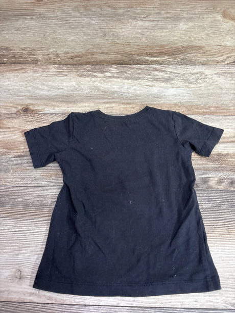 Back view of a black short-sleeved toddler t-shirt size 3T on a wooden background.