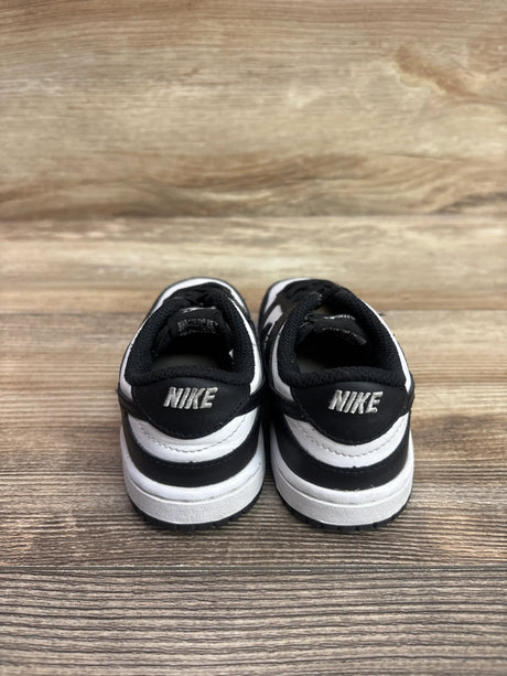 Rear view of Nike Dunk Low TD Black White sneakers showcasing black and white panels on a wood grain surface