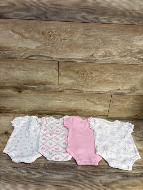 Top view of Nicole Miller 4 pack bodysuit set showcasing white and pink floral and butterfly prints on a wood floor
