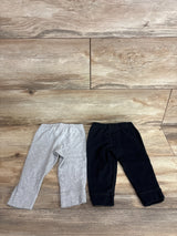 Flat lay of Carter's 2-pack 12M pull-on pants, gray and black, showing elastic waists and cuffed ankles on wood