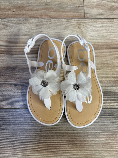 Overhead view of Bebe white chiffon flower toddler sandals size 9-10c showcasing fabric flower accents and adjustable ankle straps on wood floor