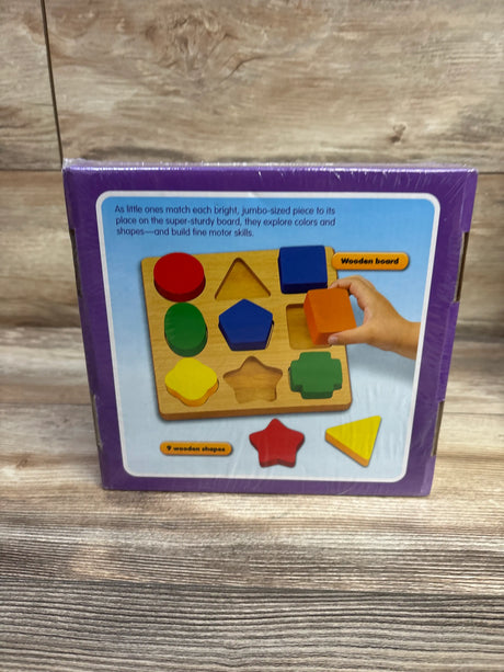 Front view of Lakeshore Simple Shapes Puzzle Board with colorful wooden shapes in purple packaging