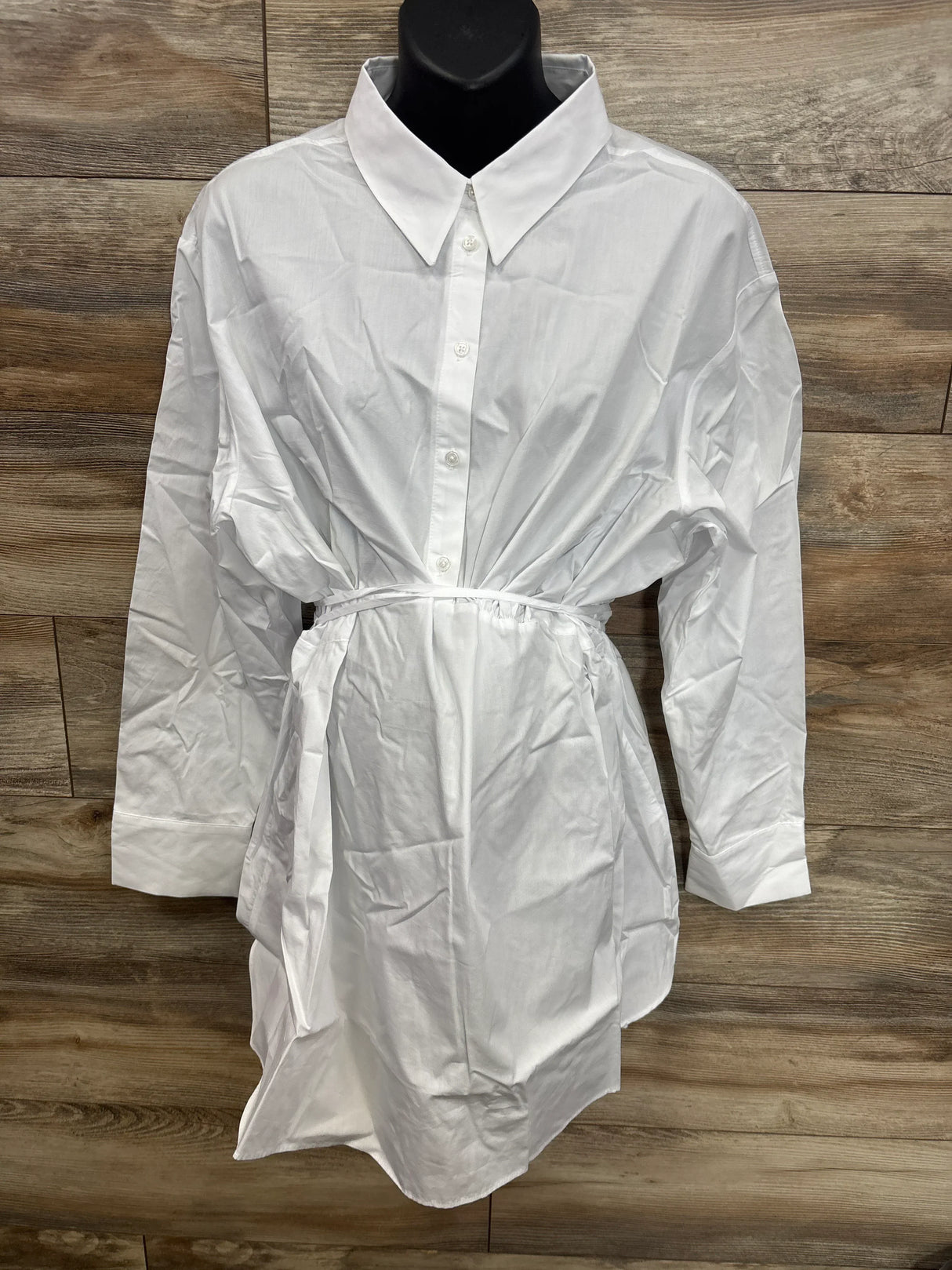 White maternity button-down shirt dress with tie waist, displayed on mannequin against wood background