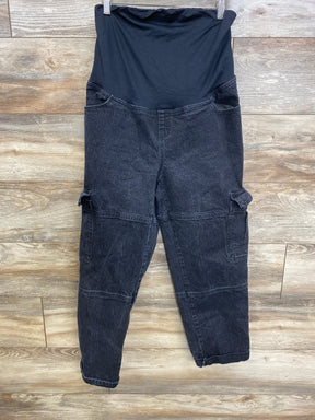 Front view of maternity 90s straight cargo jeans in black with stretch maternity panel and side cargo pockets on wood