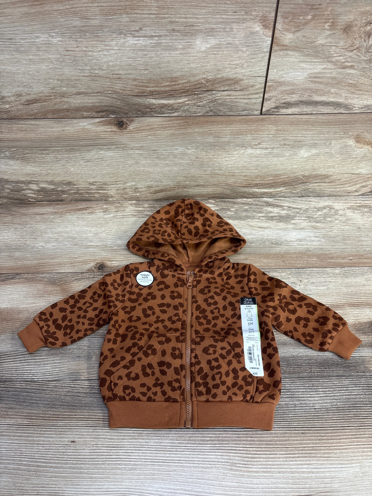 Brown leopard print baby hoodie size 3 months with front zipper on wooden floor