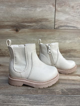 Side view of Cat & Jack Chelsea toddler boots in beige showcasing side zipper and pink sole on wood floor