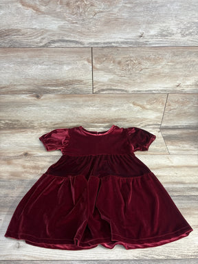 Burgundy velvet short sleeve girls dress on wood background