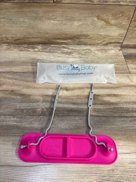 Top view of Busy Baby mini mat showing pink silicone tray with divided section and two gray adjustable toy straps