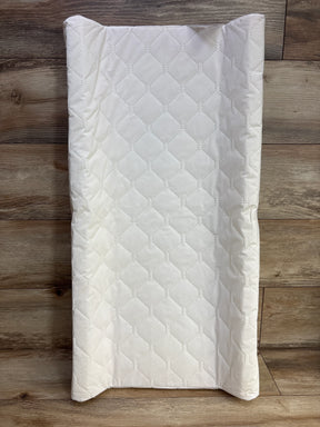 White quilted baby changing pad on wood floor, diamond pattern, kids nursery accessory