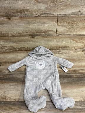 Gray plush baby onesie with hood and bear face design, lying flat on wood floor background