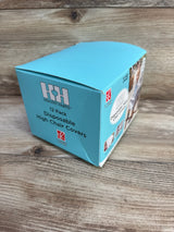 Angled three-quarter view of a 12-pack box of disposable high chair covers showcasing blue packaging and Healthy Habits branding on a wood tabletop