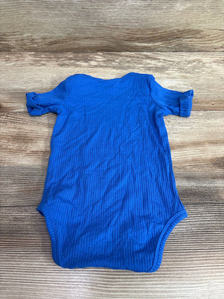 Kate Quinn ribbed modal bodysuit in blue for infants, size 3-6m, on a wood background