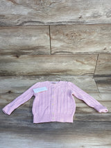Front view of Ralph Lauren cable-knit baby cardigan showing button-front closure, embroidered pony logo, and ribbed cuffs in light pink on wood background