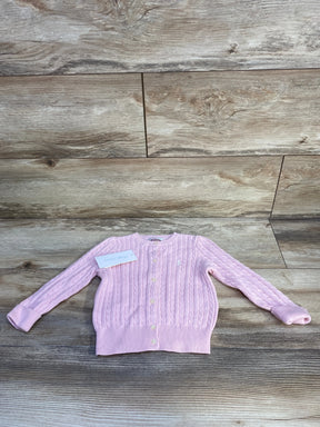 Front view of Ralph Lauren cable-knit baby cardigan showing button-front closure, embroidered pony logo, and ribbed cuffs in light pink on wood background