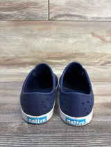 Navy blue Native kids slip-on shoes with white soles on wooden floor